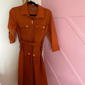 Deep orange knee length zipper front dress with collar and a belted waist